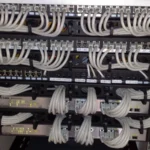 Rackmount Ethernet switches and patch panels with organized white network cables