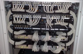 Rackmount Ethernet switches and patch panels with organized white network cables