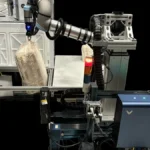 NASA robotic arm testbed moving cargo transfer bags through a spacecraft hatch in a robotics evaluation facility