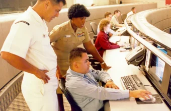 Information systems personnel studying a network operations monitor, representing Splunk incident response and vulnerability remediation