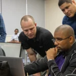 Cybersecurity responders gathered around laptops during an incident-response exercise.