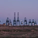 Container cranes at the Port of Antwerp, used as a metaphor for container image supply-chain migration