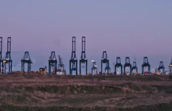 Container cranes at the Port of Antwerp, used as a metaphor for container image supply-chain migration
