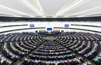 European Parliament hemicycle during a plenary session representing AI regulation and compliance governance