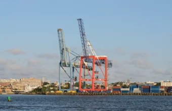 Container terminal cranes and shipping containers representing software supply-chain visibility and SBOM release gates