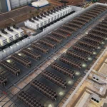 Rows of data center cooling equipment on a large facility roof, representing hosting capacity planning.