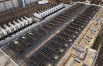 Rows of data center cooling equipment on a large facility roof, representing hosting capacity planning.