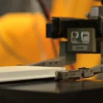 A laboratory robot arm handling an assay plate, representing low-latency remote machine control