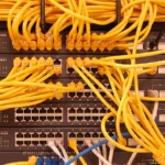 Dense yellow network cabling in a rack, illustrating the infrastructure layer behind AI inference.