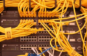 Dense yellow network cabling in a rack, illustrating the infrastructure layer behind AI inference.