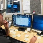 Network operations center technician working with monitors, representing managed AI-agent VPS hosting operations