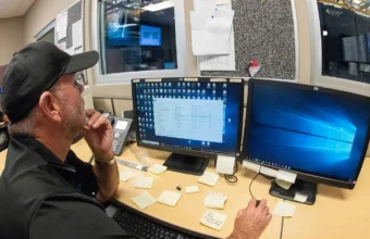 Network operations center technician working with monitors, representing managed AI-agent VPS hosting operations