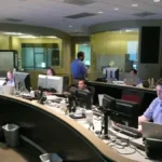 Technicians working in a network operations center with monitoring displays