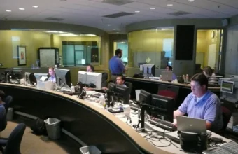 Technicians working in a network operations center with monitoring displays