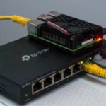 A Raspberry Pi connected to a managed Ethernet switch with yellow network cables.