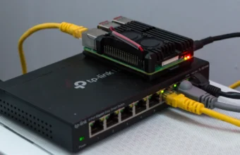 A Raspberry Pi connected to a managed Ethernet switch with yellow network cables.