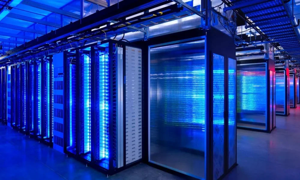 Blue-lit server racks in a modern data center, illustrating the compute infrastructure behind the AI boom.