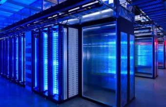 Blue-lit server racks in a modern data center, illustrating the compute infrastructure behind the AI boom.