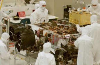 Engineers in a clean-room lab working around a robotic system, symbolizing controlled environments for AI-agent training.