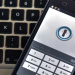 A phone security app on a smartphone resting on a laptop keyboard.