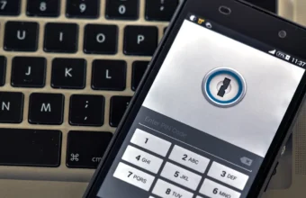 A phone security app on a smartphone resting on a laptop keyboard.