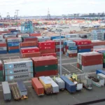 Rows of shipping containers at a port terminal, used as a physical metaphor for software supply chain security controls.