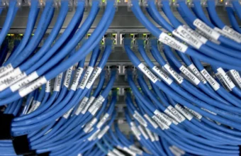 Close-up of blue Ethernet cables connected to a network switch, representing network infrastructure exposed by UniFi OS vulnerabilities.
