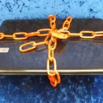 A laptop secured with a chain and padlock, symbolizing account security around encrypted messaging.