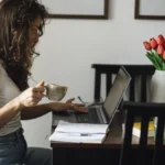 A woman working on a laptop in a home office, representing resilient software startup operations