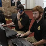 Security operations center with staff monitoring computer systems