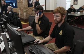 Security operations center with staff monitoring computer systems