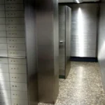 Stainless steel safe deposit boxes lining a bank vault corridor, representing secrets stored in Azure Key Vault