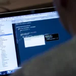 Over-the-shoulder view of code on a laptop screen