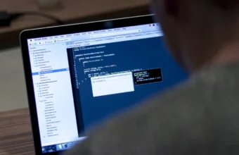 Over-the-shoulder view of code on a laptop screen