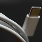 Close-up of a coiled white USB-C charging cable with its connector in focus, symbolizing a standardized connection port