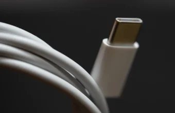 Close-up of a coiled white USB-C charging cable with its connector in focus, symbolizing a standardized connection port