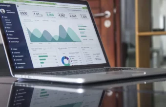 Laptop screen showing a colorful analytics dashboard with charts and graphs