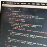 Close-up of syntax-highlighted code on a laptop screen, representing the Kubernetes tooling development behind the new Headlamp Kubeflow plugin