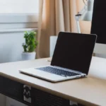 Laptop and desktop computer on a clean desk, representing a local AI development setup