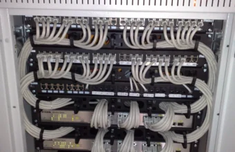 Rack-mounted Ethernet patch panels and managed switches with neatly bundled cables, symbolizing a web server wired to PHP-FPM