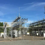High-voltage electrical substation equipment behind a chain-link fence in Manassas Park, Virginia