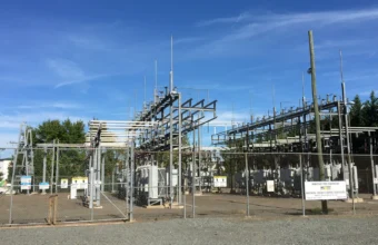 High-voltage electrical substation equipment behind a chain-link fence in Manassas Park, Virginia