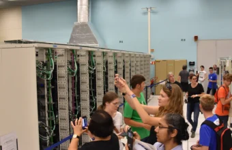 Rows of server racks in a data center computer room, representing a Kubernetes fleet spread across many clusters