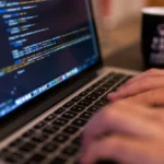 Computer programmer typing code on a laptop representing enterprise Java migration work