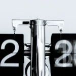 Black and white flip clock showing 12:30 AM, representing a task that runs automatically on a schedule