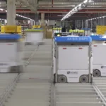 Rows of autonomous Ocado warehouse robots moving along a shared grid track system