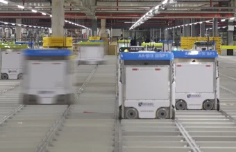Rows of autonomous Ocado warehouse robots moving along a shared grid track system