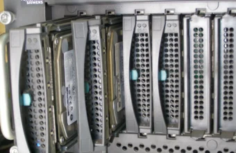 Close-up of hot-swap hard drive bays in a rack-mount Fujitsu Siemens Primergy server, the kind of physical hardware MAAS discovers and provisions