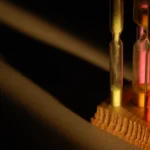Four colorful hourglasses in a light beam, illustrating how a dependency cooldown makes package managers wait before trusting a new release