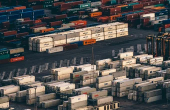 Aerial view of stacked shipping containers from many carriers at a busy container port